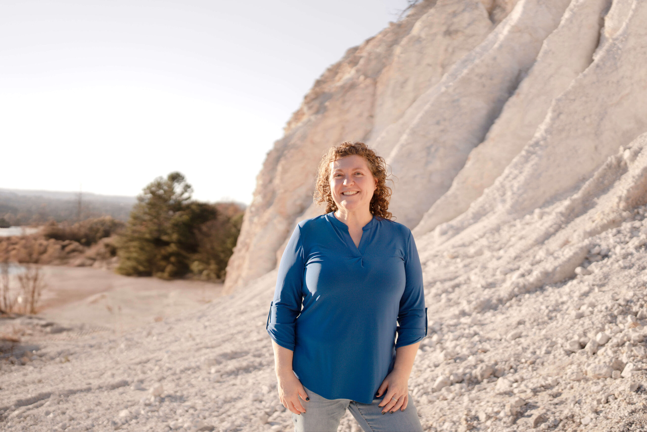 Nicky Reynolds of Nicky Reynolds freelance marketing and pr in a blue shirt standing in front of a rocky backdrop